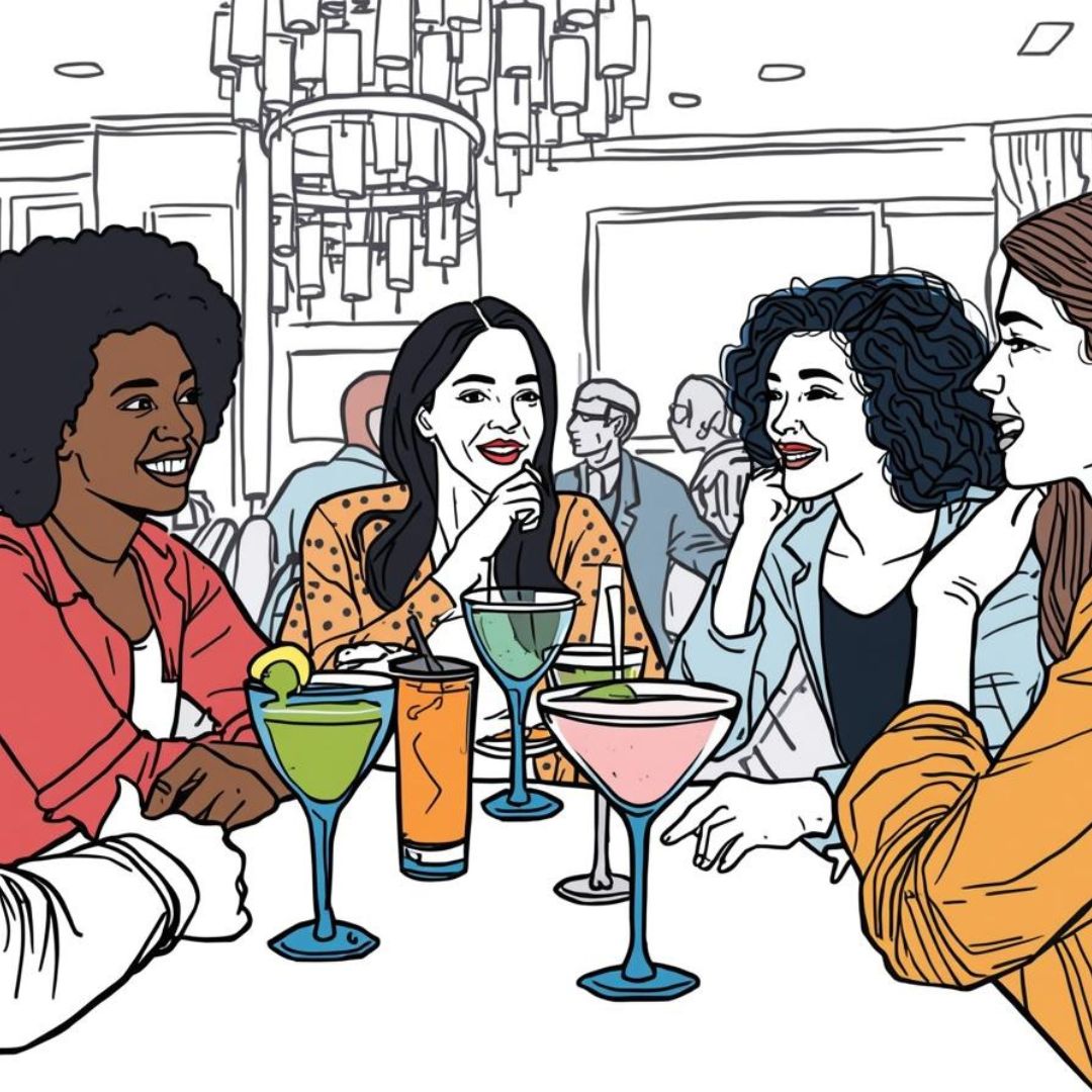 Four women chatting around a table with various colourful drinks in a social setting.
